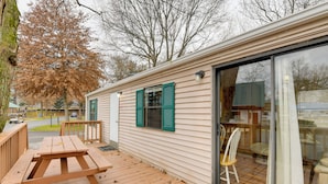 A wooden deck with a picnic table, a sliding glass door, and a chair. - Resort-style Adventure Base in the Blue Ridge Mtns (Waynesville)