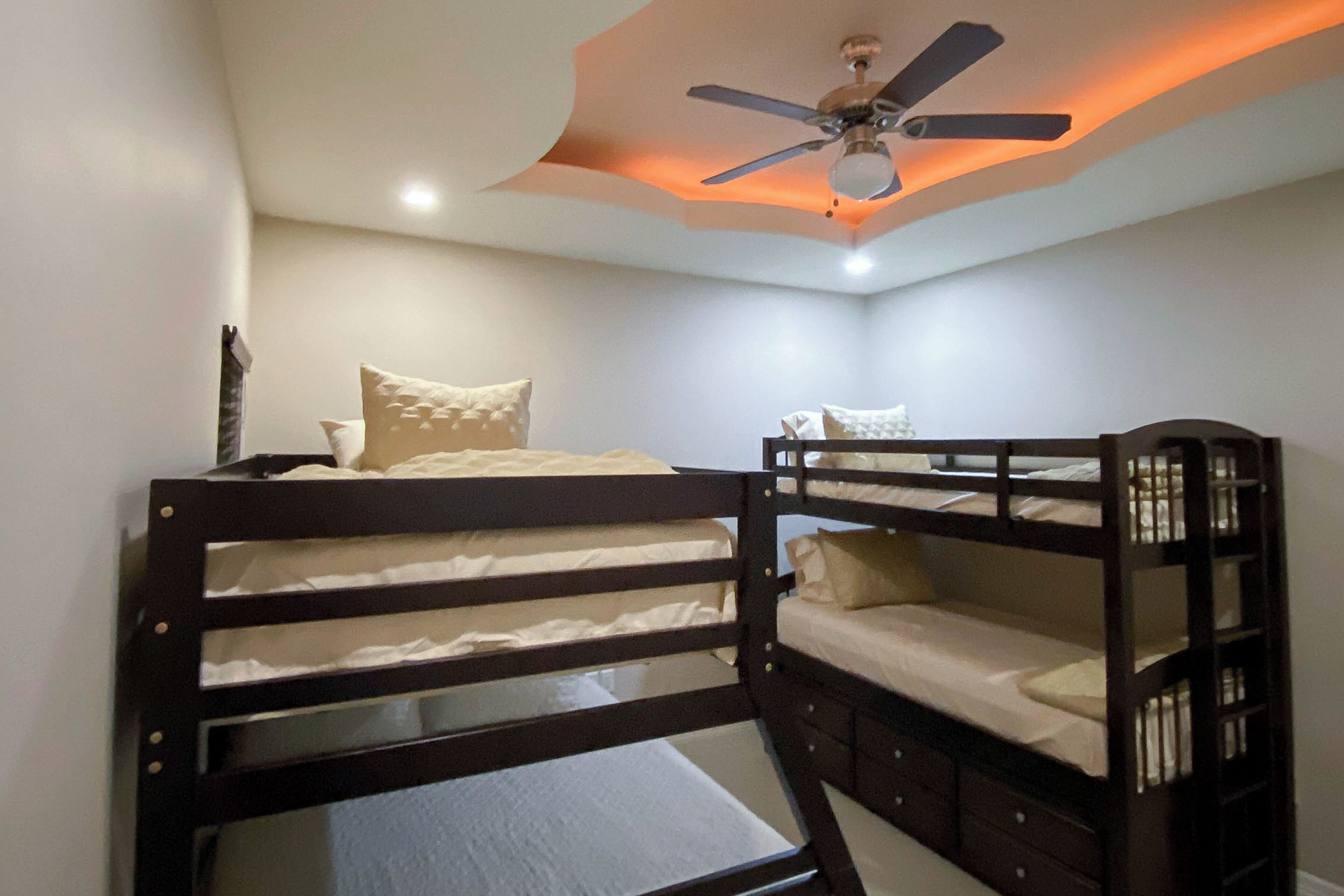 A bunk bed room with a ceiling fan and recessed lighting.