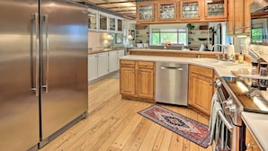 A modern kitchen with wooden cabinets, stainless steel appliances, and a large island. - Vibrant 3BR Near Downtown w/ Fireplaces (Fairbanks)