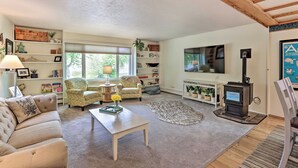 A cozy living room with a sofa, armchairs, a coffee table, a fireplace, and a bookshelf. - Vibrant 3BR Near Downtown w/ Fireplaces (Fairbanks)