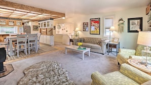 A cozy living room with a sofa, armchairs, a coffee table, and a dining area with chairs and a table. - Vibrant 3BR Near Downtown w/ Fireplaces (Fairbanks)