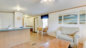Amplia sala de estar con cocina, mesa de comedor y un sofá cómodo.