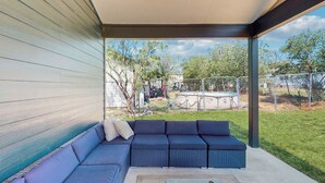 A covered outdoor seating area with a sectional sofa and a small table. - Modern Living in Texas! Home 2 Blocks to Lake LBJ (Marble Falls)