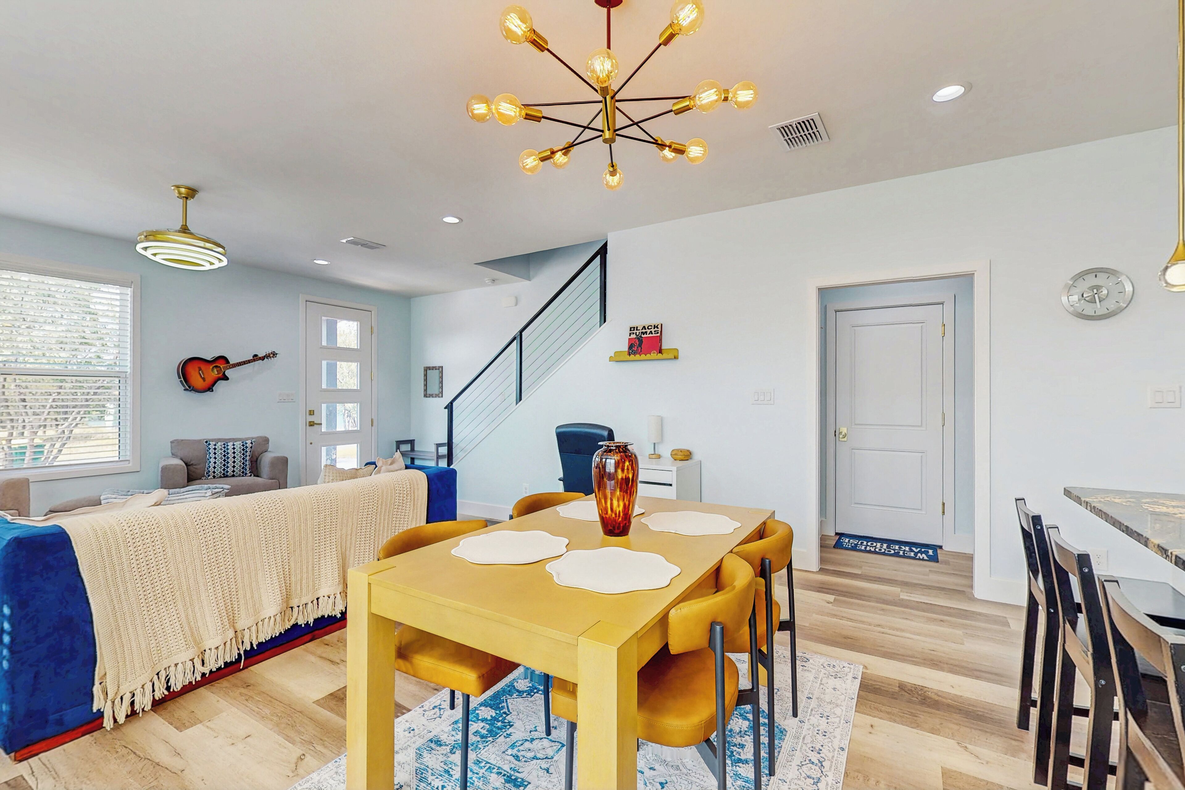 A dining area with a wooden table and chairs, a decorative vase, and a ceiling light fixture.