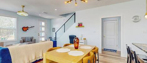 A dining area with a wooden table and chairs, a decorative vase, and a ceiling light fixture.