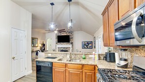 A modern kitchen with granite countertops, wooden cabinets, a dishwasher, a stove, and a microwave. - 5 Mi to Cedar Hill SP & Joe Pool Lake: Family Home (Cedar Hill)