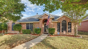 A brick house with a front entrance, a flag, and a well-maintained lawn. - 5 Mi to Cedar Hill SP & Joe Pool Lake: Family Home (Cedar Hill)