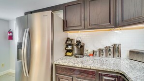 A modern kitchen with dark wood cabinets, a stainless steel refrigerator, a coffee maker, and a toaster. - Pet-friendly Apt Near Ocoee River & Waterfalls (Etowah)