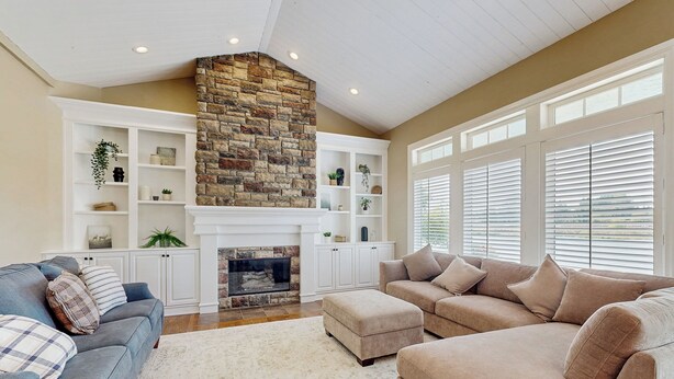 A spacious living room with a fireplace, built-in shelving, and large windows. - Plummer Lakefront Home: Fish & Kayak (Centralia)