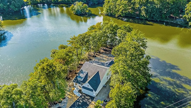 A lakeside property with a white building, a covered driveway, and a boat dock. - 3BR Riverfront Home w/ Kayaks & Game Room (Seaford)