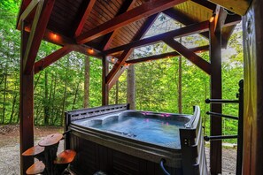 A hot tub under a wooden pavilion with a forest backdrop. - Beautiful Wood Cabin in Red River Gorge (Rogers)