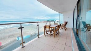 Un balcon avec vue sur la plage et l’océan.
