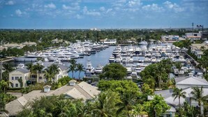 A marina with numerous boats docked, surrounded by residential buildings and lush greenery. - Waterfront Elegance Near Cruiseport | Pool & Gym (Fort Lauderdale)