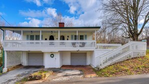 Une maison à deux étages avec un porche à l’avant, deux garages et un escalier menant à l’étage supérieur.