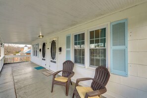A covered porch with two wooden chairs and a door with blue shutters. - Peaceful Duplex - Walk to Historic Jonesborough! (Jonesborough)