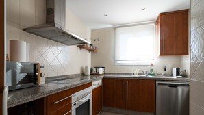 A modern kitchen with a microwave, toaster, oven, and dishwasher. - Sea Views Lagos de Santa Maria - By Time and Home (Marbella)
