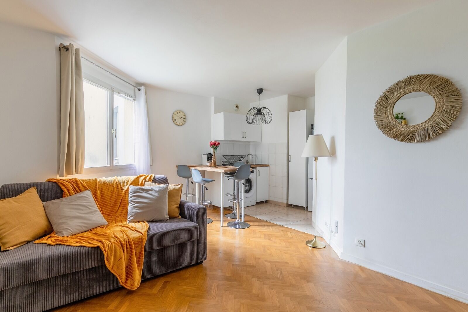Un salon moderne comprenant un canapé, un coin repas et une cuisine.