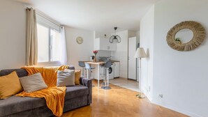 Un salon moderne comprenant un canapé, un coin repas et une cuisine.