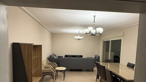 En matplats med ett långt bord och stolar, en soffa och en liten sittgrupp med fåtöljer.