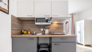 A compact kitchen with a microwave, toaster, and sink.