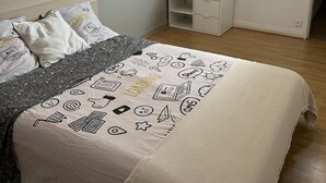 Ein Schlafzimmer mit einem Bett, einem Kleiderschrank, einer Garderobe und einer Wanduhr.