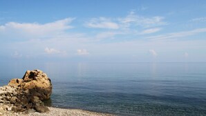 Costa rocosa con agua cristalina y un mar en calma.