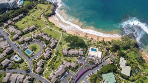 An aerial view of a coastal residential area with a beach, houses, and a swimming pool. - Wailea Elua Village 1702- 2Bdr+2Bath Condominium-Only Steps to the Ocean! (Wailea)