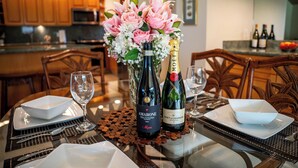 A dining table set with a bottle of Amarone wine, a bottle of Moet & Chandon champagne, and a bouquet of pink flowers. - Wailea Elua Village 1702- 2Bdr+2Bath Condominium-Only Steps to the Ocean! (Wailea)