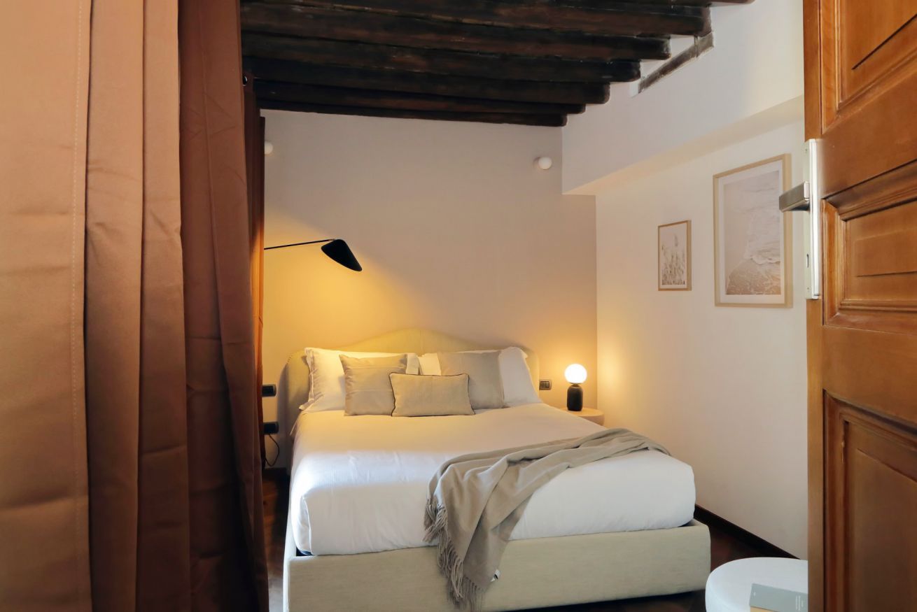 Ein Schlafzimmer mit einem Bett, Nachttischlampen und einem Nachttisch.