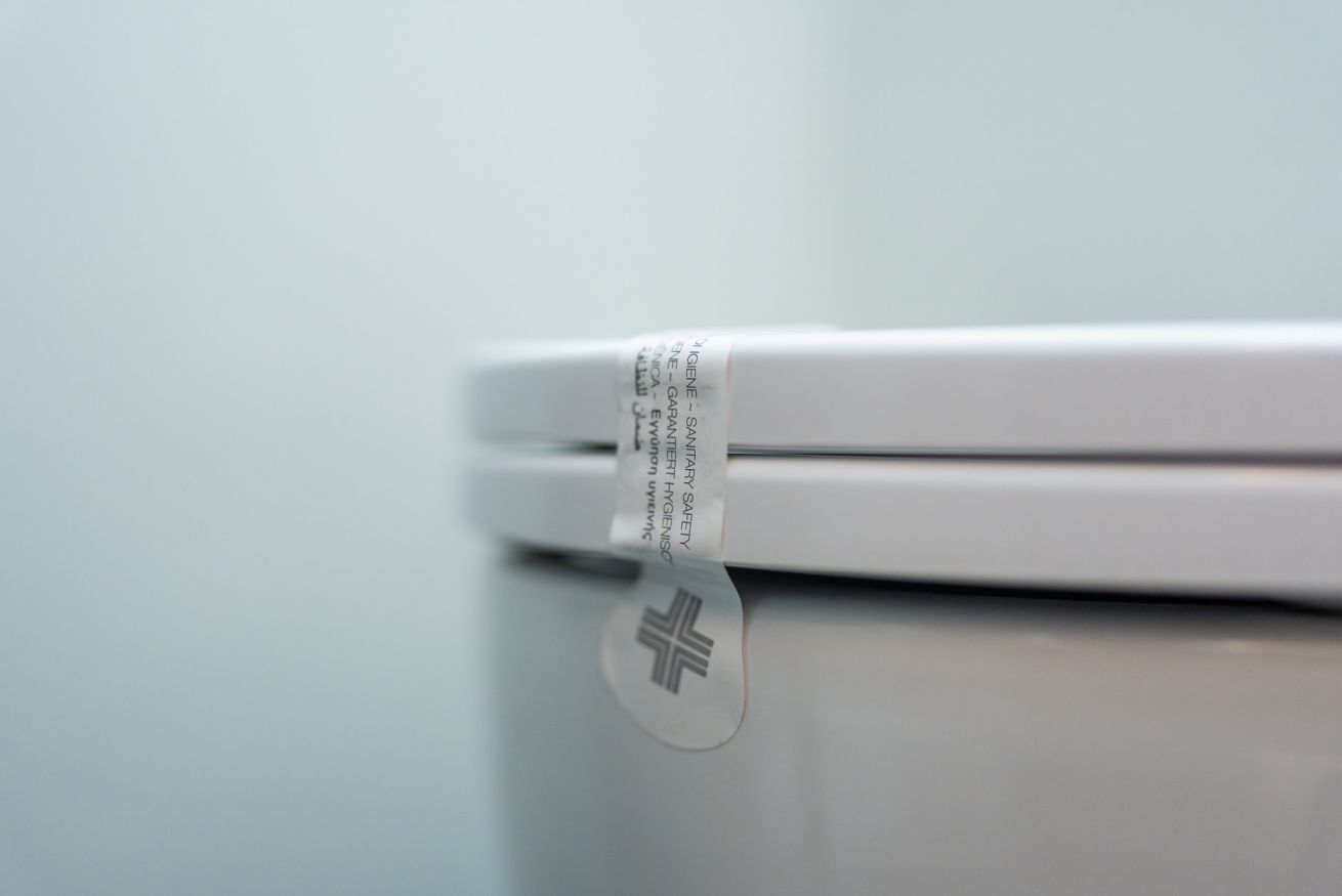 A white object with a safety label and a cross symbol.