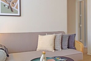 Ein Wohnzimmer mit einer Couch, einem Couchtisch und einem gerahmten Bild an der Wand.