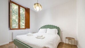 A bedroom with a bed, a window, a radiator, and a small table. - Cami’s Corner - Heart of Cagliari (Cagliari)