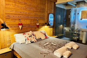 A wooden-paneled room with a bed, a mirror, a shower, and a sink.