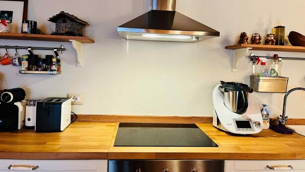 A kitchen with a stainless steel range hood, a built-in oven, a coffee maker, and a toaster. - GuestHost - Charming 70 sqm apartment on two levels, comfortably accommodating four people.The property is located in La Salle, in the hamlet of Cottin, surrounded by Alpine nature at the foot of Mont Blanc, an ideal location for skiers and outdoor sport (La Salle)