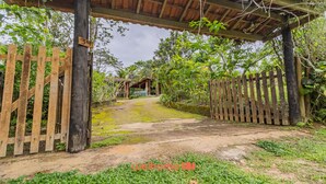 A rustic wooden gate leading to a covered pathway surrounded by lush greenery. - Casa em Ubatuba a 10 minutos de carro da praia (Ubatuba)