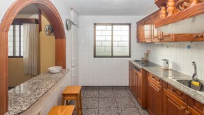 Eine Küche mit Granit-Arbeitsplatten, Holzschränken, einem Fenster und einer Spüle.