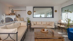 A living room with a sofa, coffee table, and decorative items. - Maison L'étoile de Sidi Bou Saïd - 360° Sea View (Sidi Bou Said)