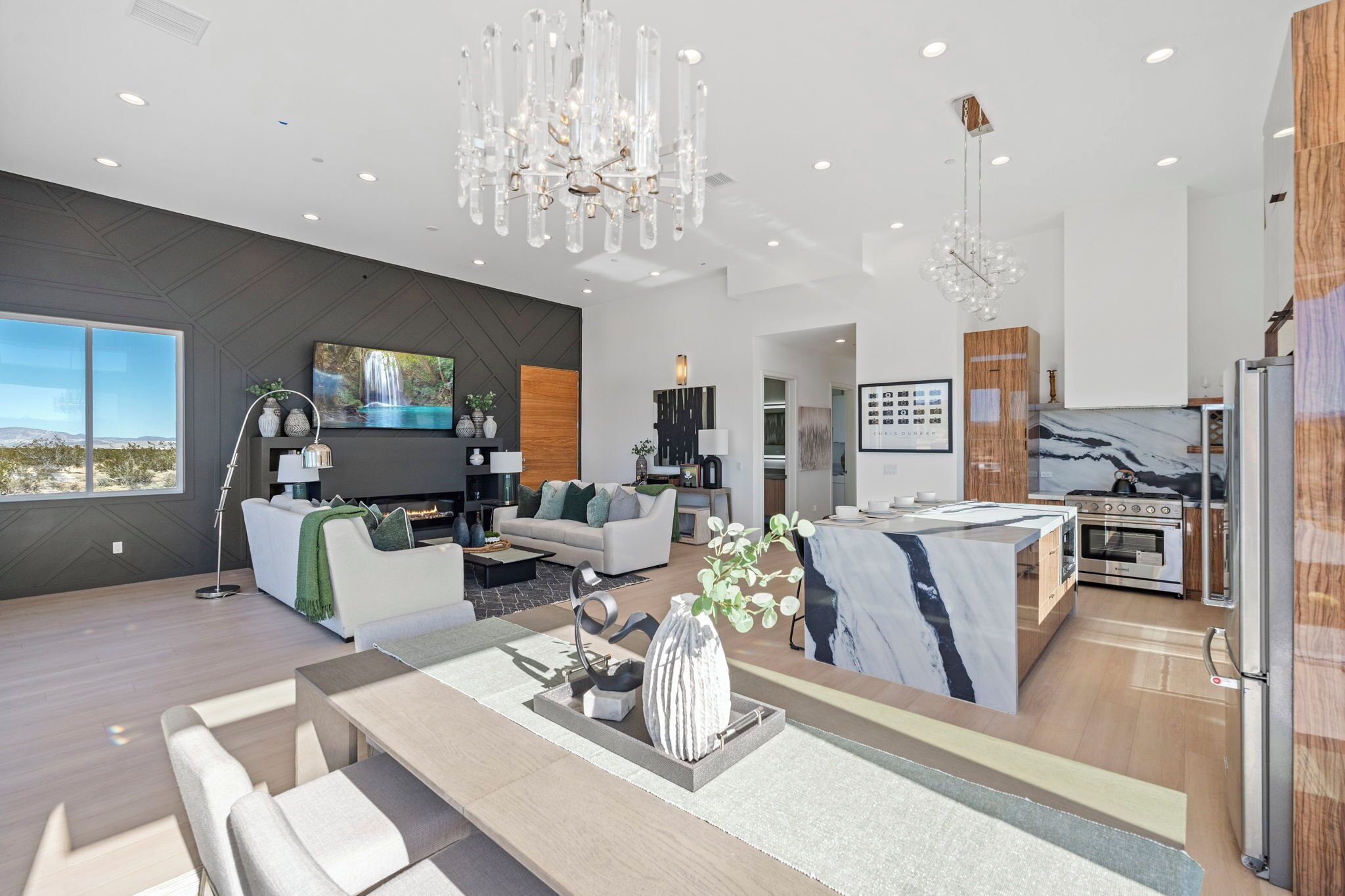 A modern living room with a large TV, sofa, and dining area.