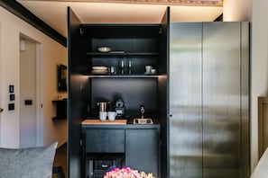 A modern kitchen with built-in appliances, a coffee machine, and a microwave. - HH - Suite Giulia - MyHomeinComo (Argegno)