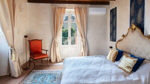 A bedroom with a bed, a chair, a window with curtains, and a painting on the wall. - Pink Villa - MyHomeinComo (Carate Urio)