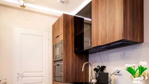 Een moderne keuken met houten kastjes, een zwarte magnetron en een roestvrijstalen spoelbak.