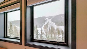 Drei Fenster mit Blick auf eine verschneite Landschaft und Bäume.