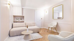 Et moderne, minimalistisk soveværelse med seng, sengeborde, en stol og et spejl.