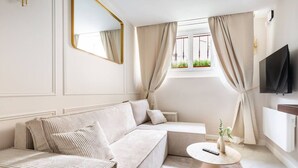 Un salon moderne avec un canapé, une table basse et un téléviseur.