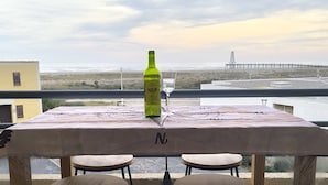 A table with a bottle and glass on a balcony overlooking a beach and a pier. - Studio port Leucate, first line beach (Leucate)