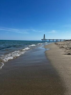 Una spiaggia con un molo che si protende verso il mare.