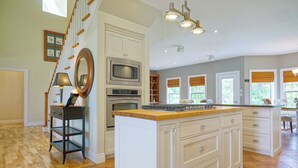 A spacious kitchen with a central island, built-in appliances, and a staircase leading to another level. - Harbourview Retreat - Waterview Luxury Home Steps from the Inn at Bay Fortune (Rock Barra)