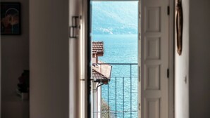 Een deur naar een balkon met uitzicht op zee en bergen.