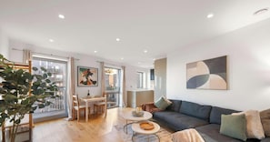 Ein modernes Wohnzimmer mit Sofa, Couchtisch und Essbereich.
