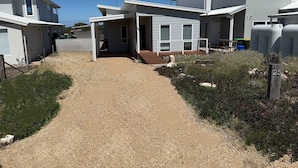 A modern residential area with multiple houses, a gravel driveway, and a well-maintained garden.